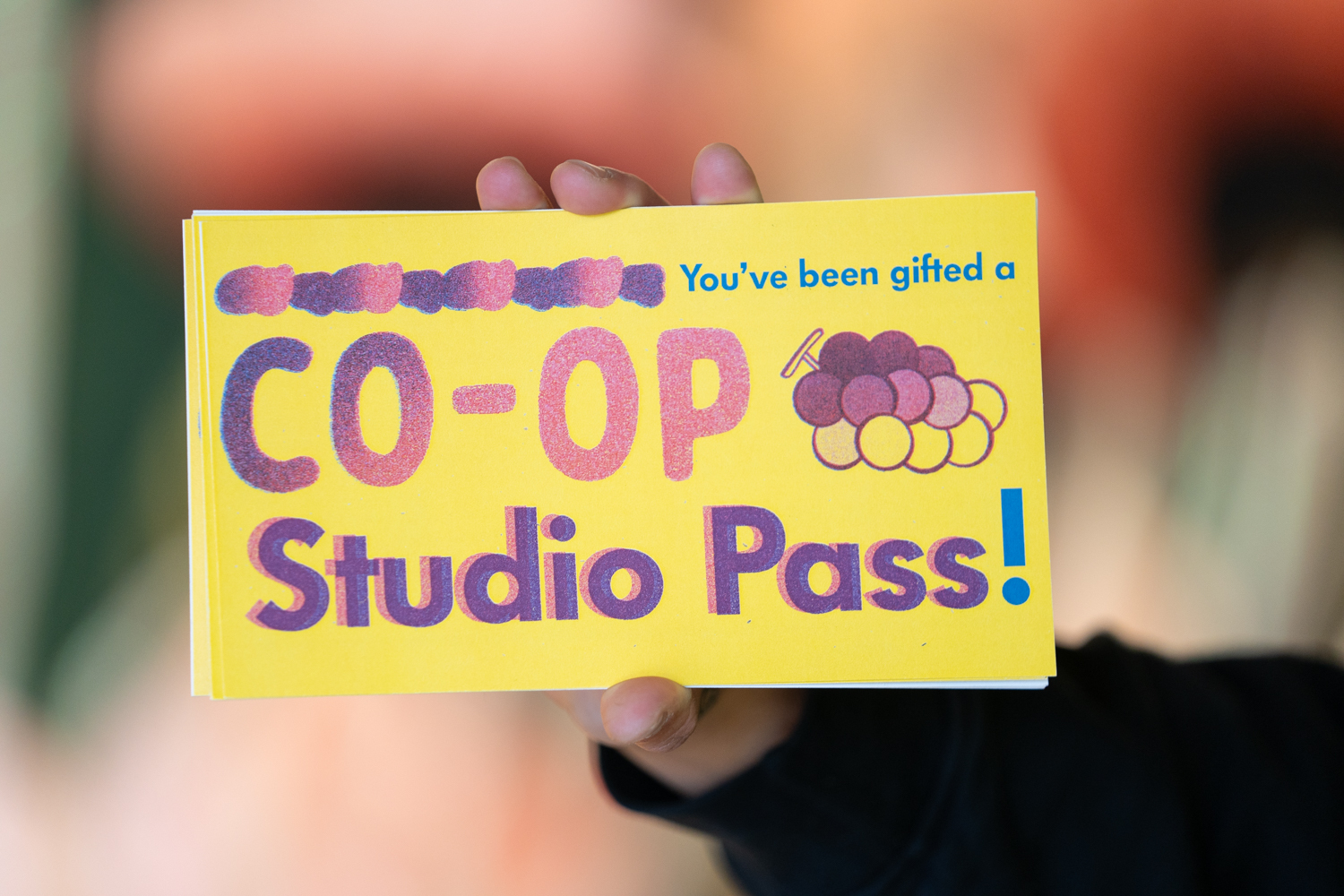 A close up of a colorful paper that says Co Op Studio Pass