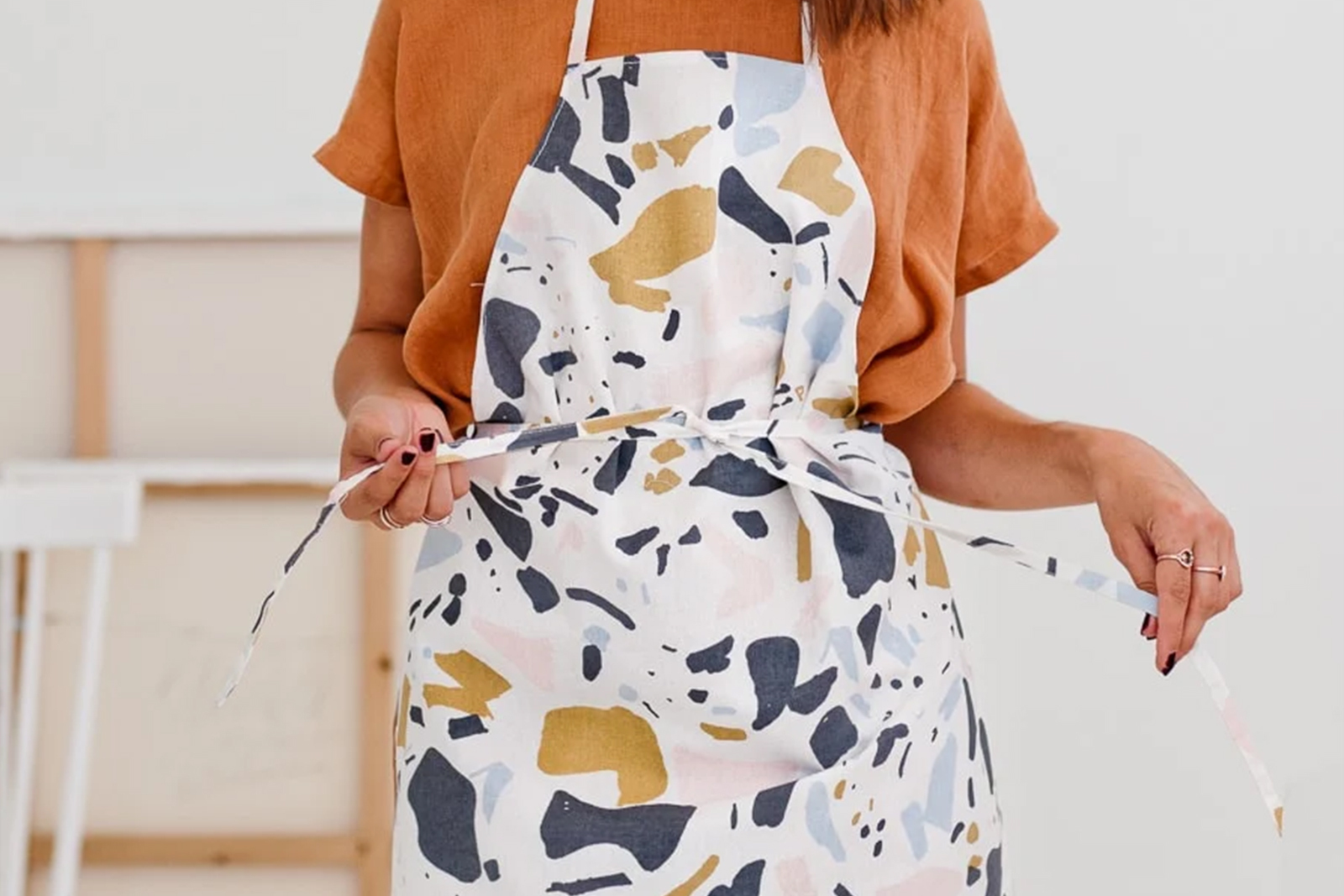 A stock photo of a person wearing a simple kitchen apron