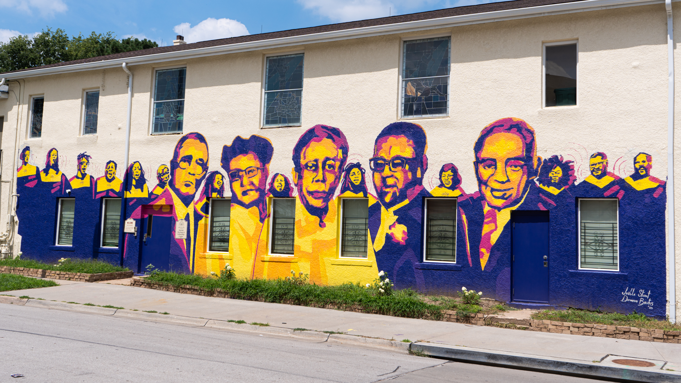 A view from the street of a multicolor mural of church leaders and choir memebers on the side of Mount Moriah Church