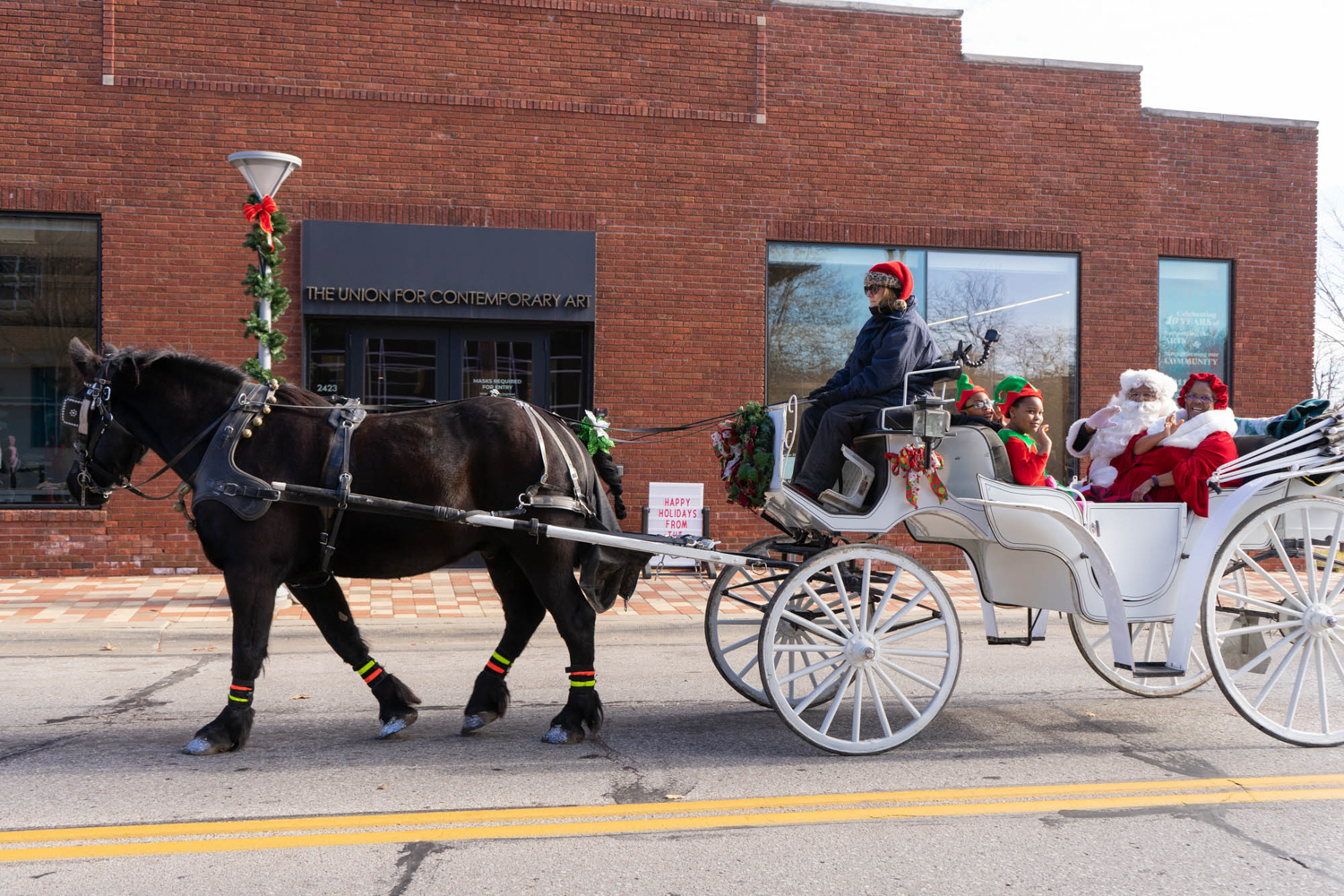 Christmas in the Village Horse drawn carriage passes by The Union during the parade