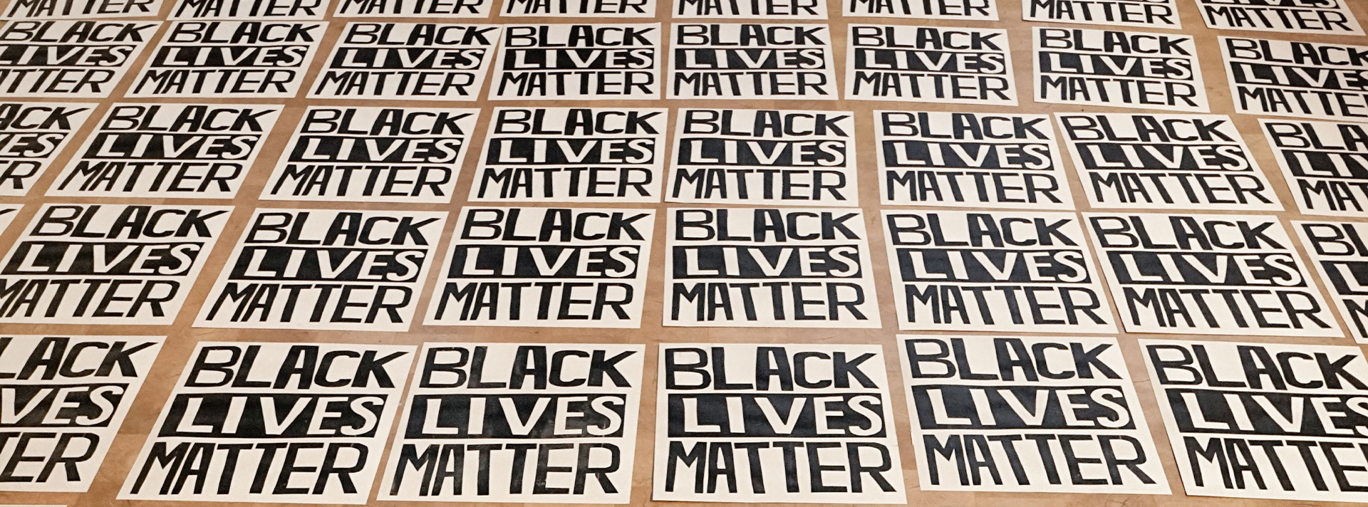 Hundreds of black lives matter posters laying on the wanda d ewing gallery floor