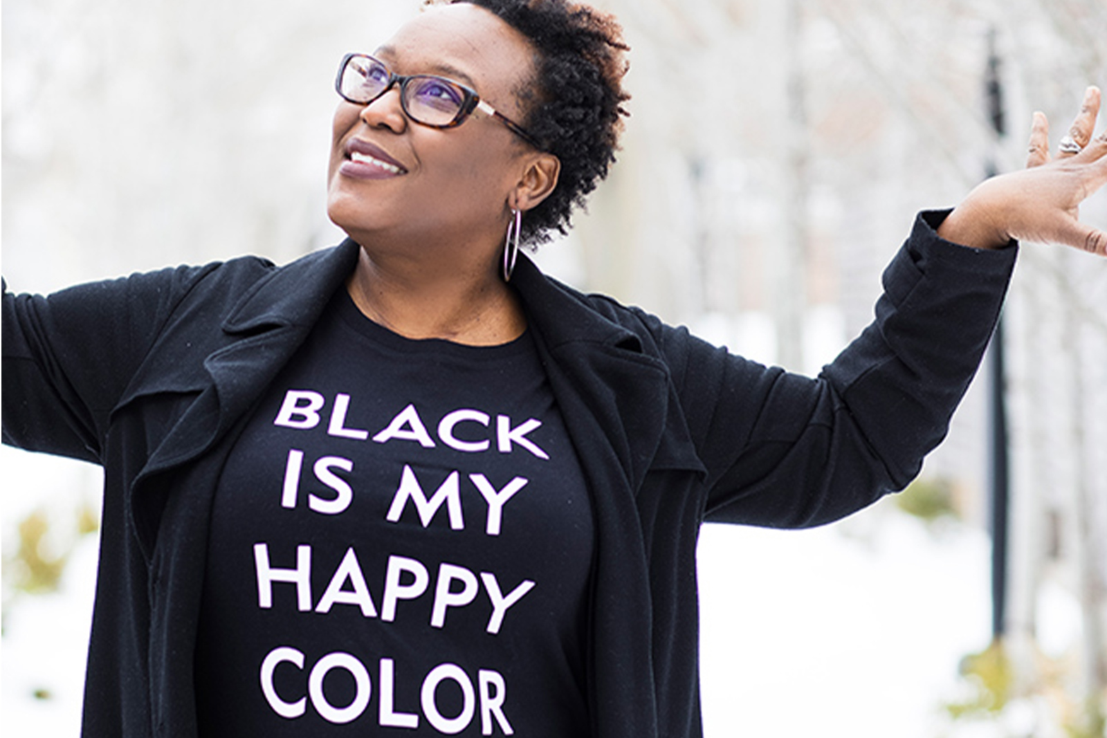 Portrait photo of Zedeka Poindexter standing inte snow wearing a t shirt that reads Black is my Happy Color landscape