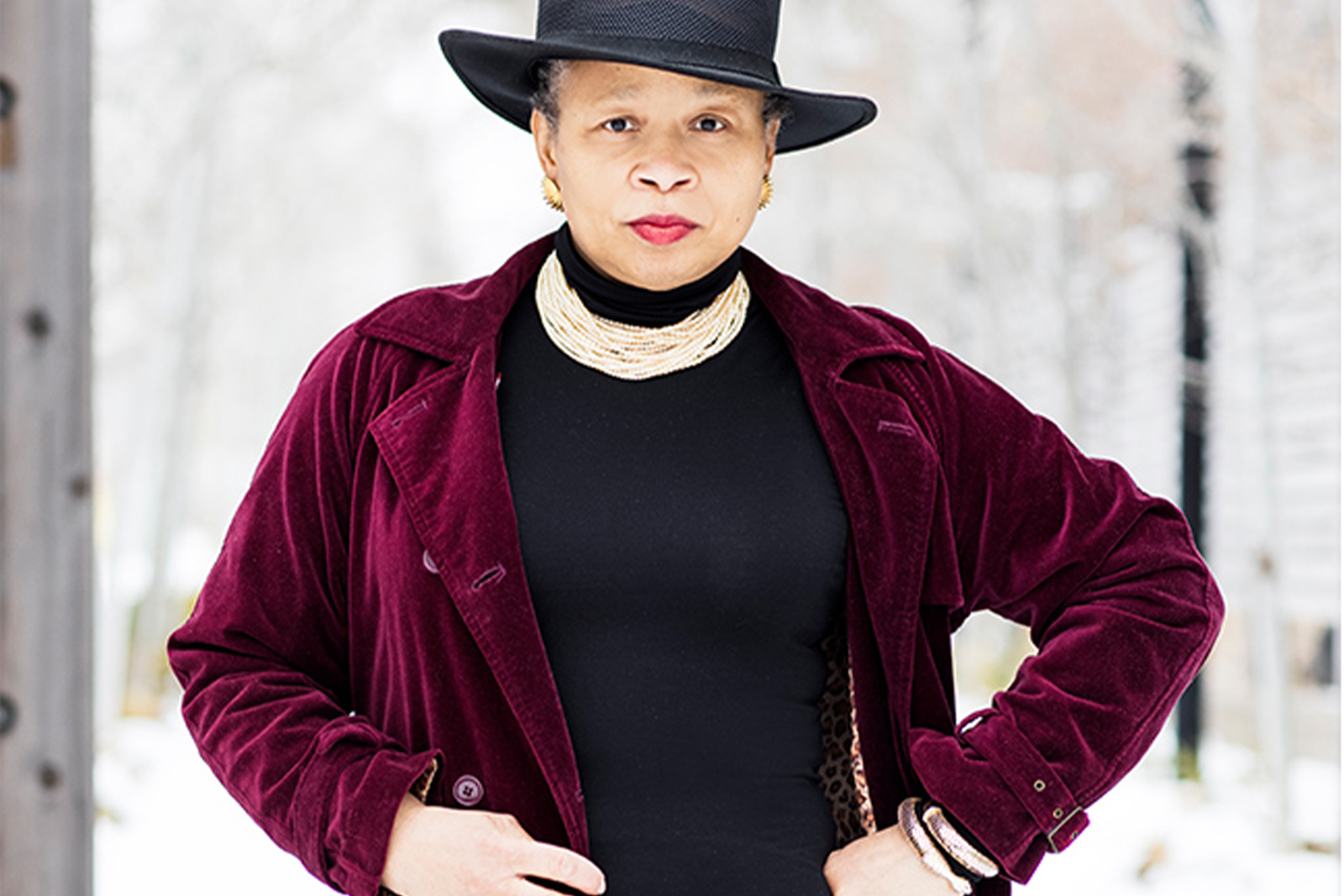 Portrait photo of pamela conyers hinson standing in a red velvet duster coat in the snow landscape